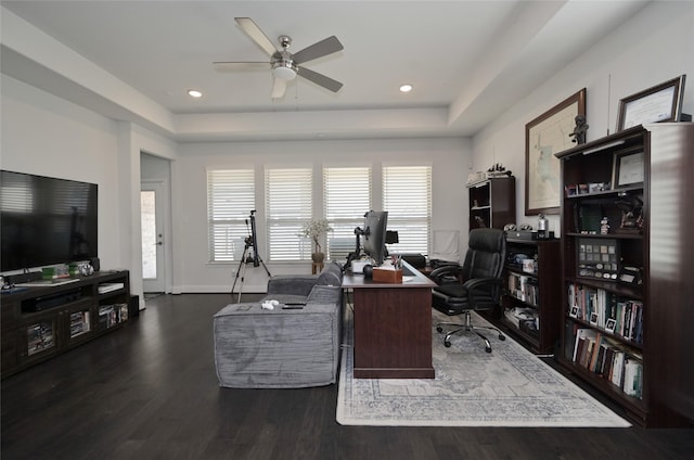 home office featuring wood finished floors, baseboards, a tray ceiling, recessed lighting, and ceiling fan