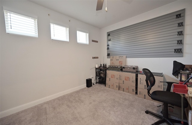 carpeted office space with baseboards and a ceiling fan