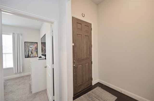 interior space with dark colored carpet and baseboards