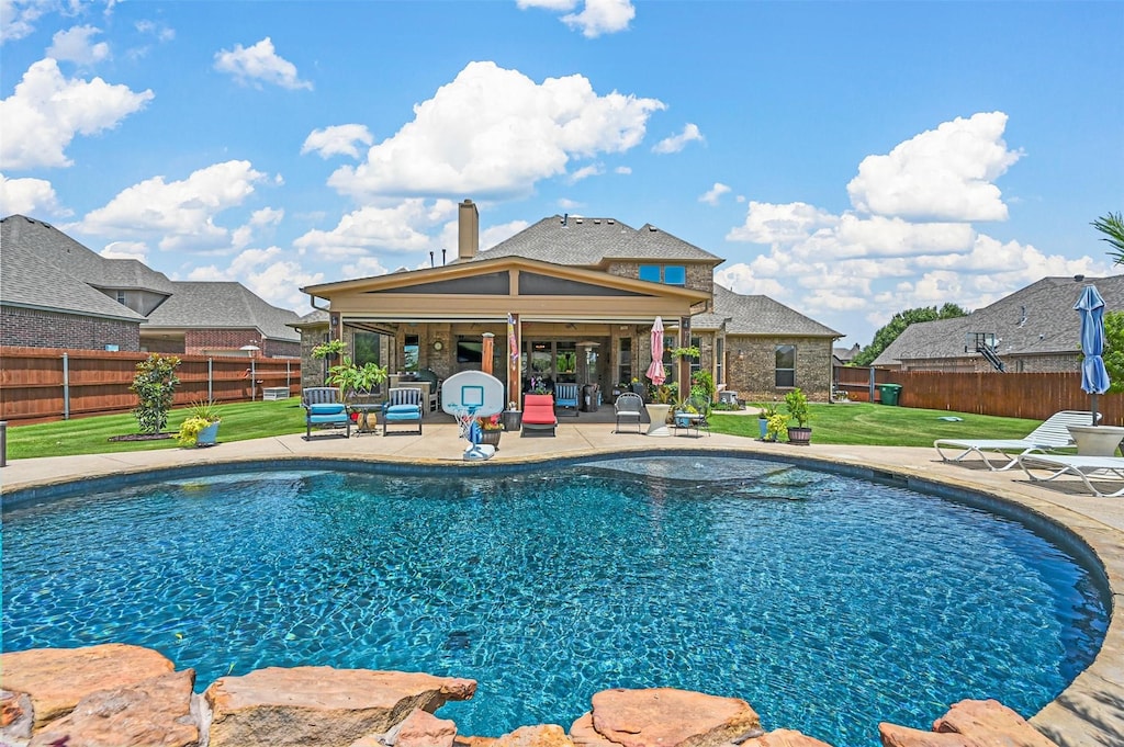 view of pool featuring a yard, a fenced backyard, a fenced in pool, and a patio