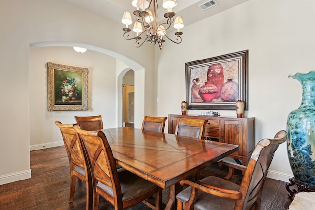 dining area with arched walkways, visible vents, baseboards, and dark wood-style floors