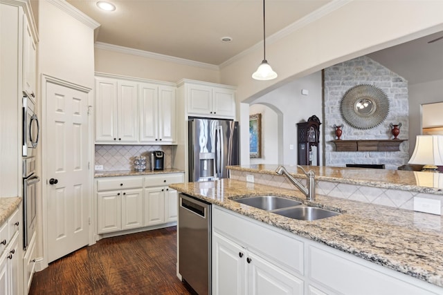 kitchen featuring dark wood-type flooring, a sink, backsplash, stainless steel appliances, and crown molding