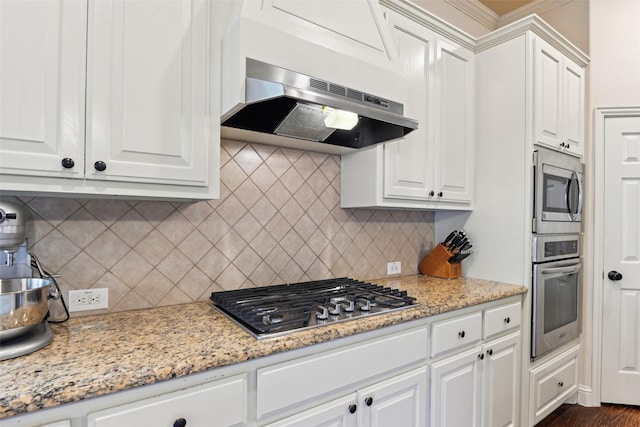 kitchen featuring under cabinet range hood, stainless steel appliances, and white cabinetry