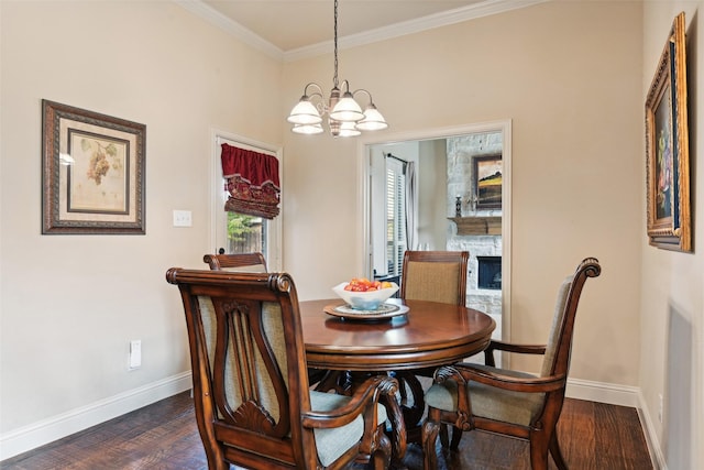 dining room featuring dark wood finished floors, crown molding, a fireplace, and baseboards