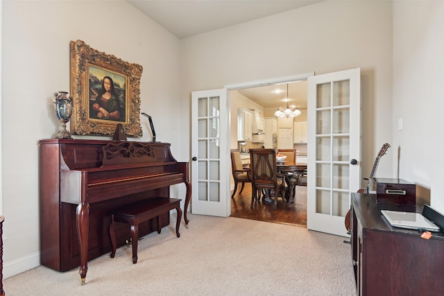 living area featuring french doors, a notable chandelier, and light colored carpet