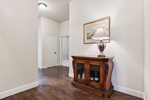 corridor featuring wood finished floors and baseboards