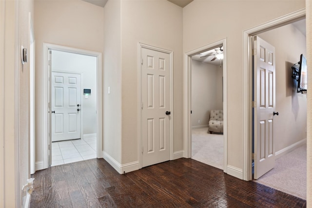 hall with dark wood-type flooring and baseboards