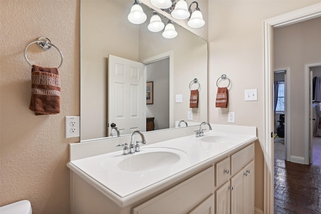 bathroom featuring double vanity, wood finished floors, and a sink