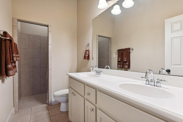 full bathroom with a sink, tiled shower, double vanity, and tile patterned flooring