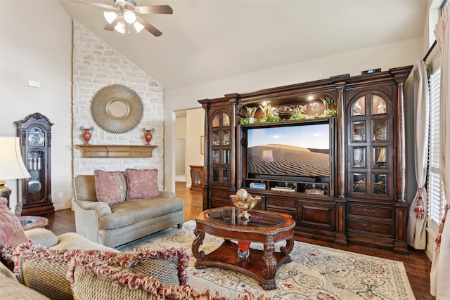 living room with a ceiling fan, vaulted ceiling, and wood finished floors