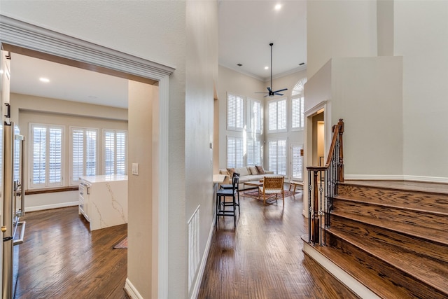 foyer entrance with a ceiling fan, dark wood-style floors, visible vents, baseboards, and a high ceiling