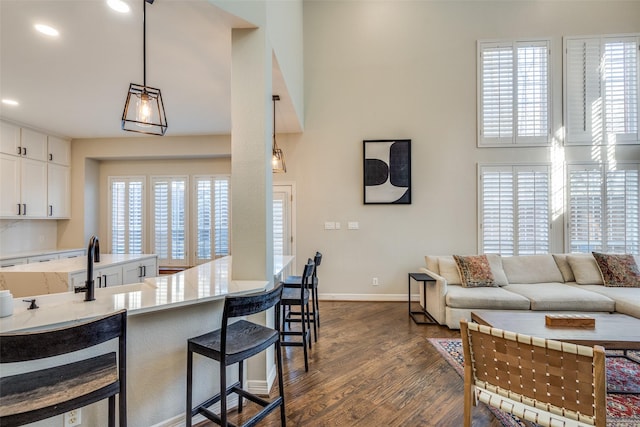 kitchen with plenty of natural light, dark wood-type flooring, a breakfast bar, and white cabinetry