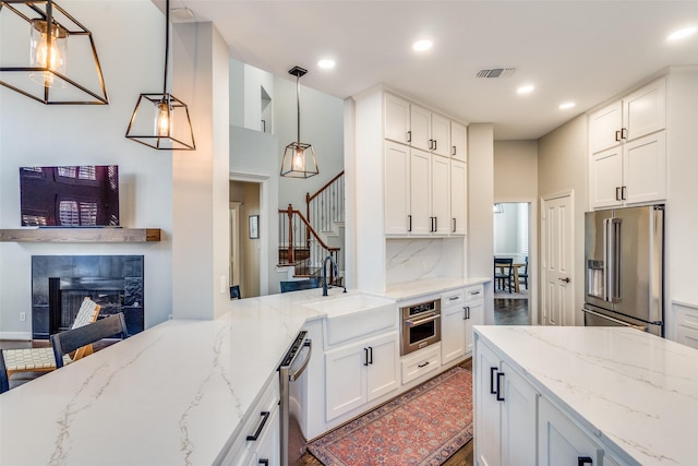 kitchen featuring white cabinets, tasteful backsplash, appliances with stainless steel finishes, and a sink