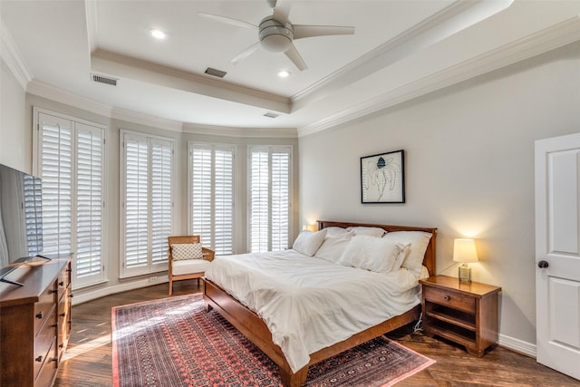 bedroom with wood finished floors, visible vents, a tray ceiling, recessed lighting, and ornamental molding