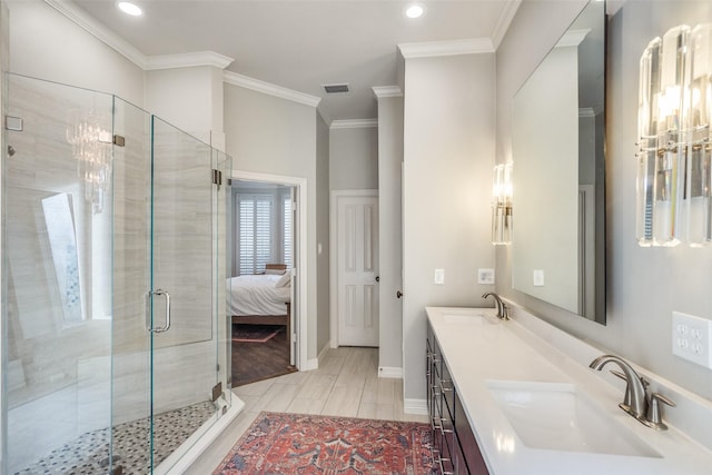 full bathroom with double vanity, ornamental molding, a stall shower, and a sink