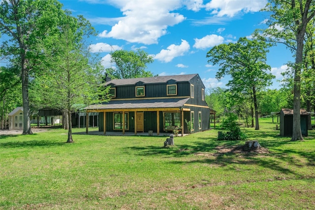 view of front facade featuring a carport, a front lawn, and an outdoor structure