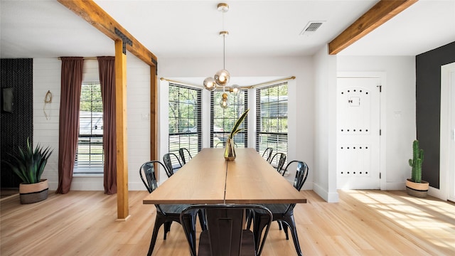 dining room with visible vents, baseboards, a chandelier, beam ceiling, and light wood-style floors