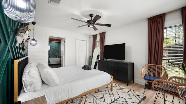 bedroom with ceiling fan, visible vents, ensuite bathroom, and light wood-type flooring