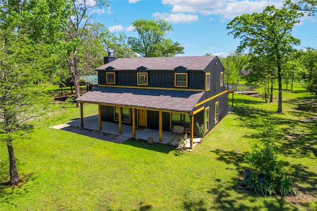 back of house with a patio, a lawn, and a shingled roof