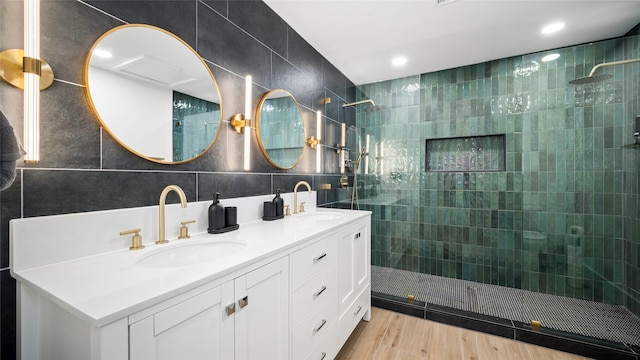 bathroom featuring tile walls, a walk in shower, and a sink