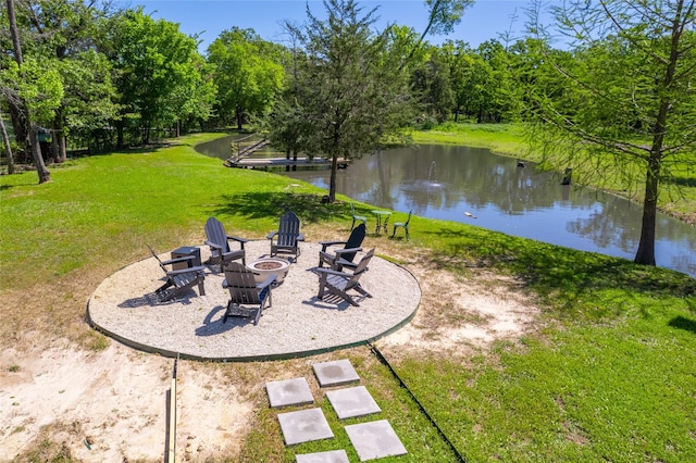 view of yard with a patio, a water view, and an outdoor fire pit