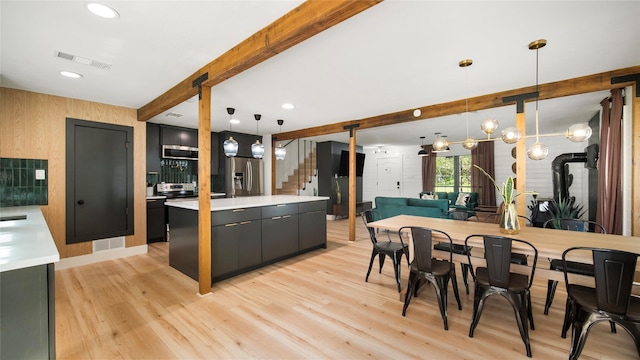kitchen featuring visible vents, light wood-style floors, stainless steel refrigerator with ice dispenser, beamed ceiling, and a center island
