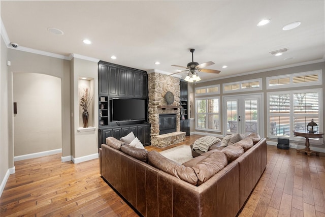 living room featuring ceiling fan, light wood-type flooring, and ornamental molding