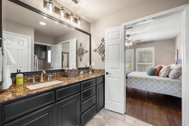 ensuite bathroom featuring vanity, wood finished floors, a ceiling fan, and ensuite bathroom