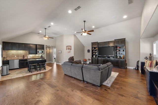 living area with wood finished floors, a ceiling fan, and visible vents