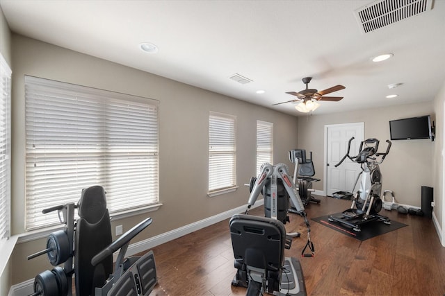 workout room featuring ceiling fan, visible vents, baseboards, and wood finished floors