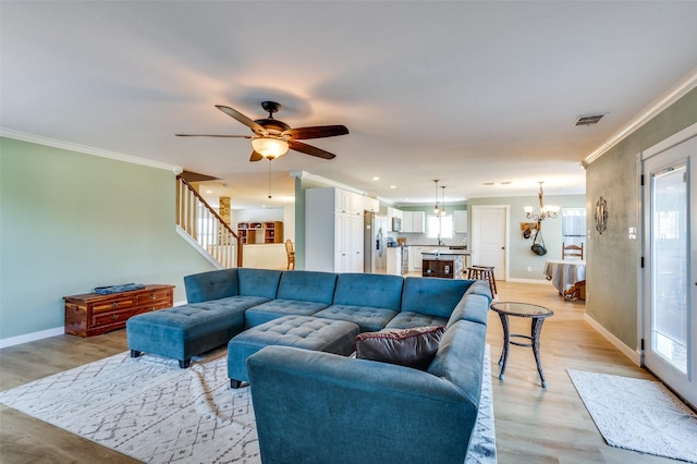 living room featuring visible vents, light wood-style flooring, baseboards, and ornamental molding