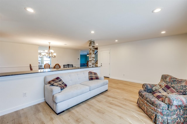 living room featuring light wood-style flooring, recessed lighting, baseboards, and a chandelier