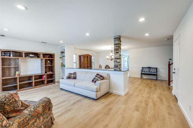 living area featuring recessed lighting, light wood-style floors, visible vents, and ornate columns