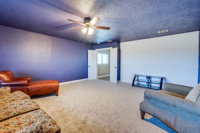 living room with carpet, visible vents, baseboards, ceiling fan, and a textured ceiling