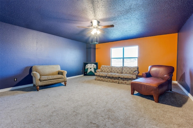 sitting room with carpet flooring, a textured ceiling, baseboards, and a ceiling fan