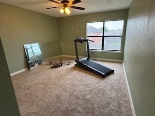 exercise area featuring carpet floors, a healthy amount of sunlight, a ceiling fan, and baseboards