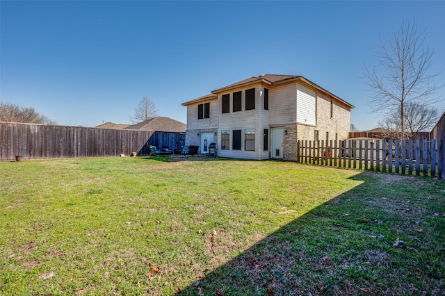 back of property featuring a yard and a fenced backyard