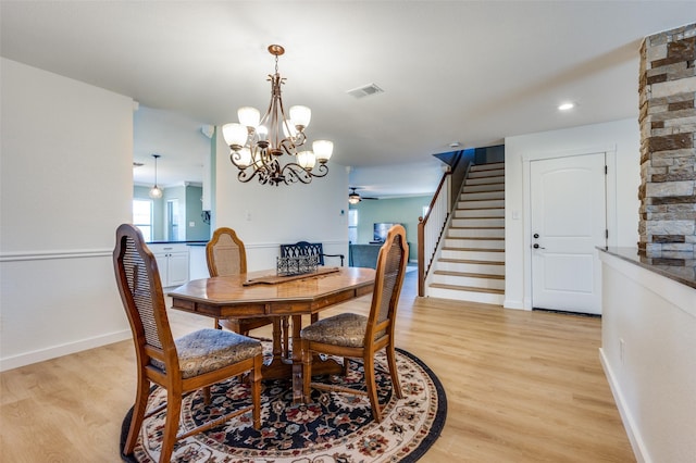 dining room featuring visible vents, stairway, light wood-type flooring, and baseboards