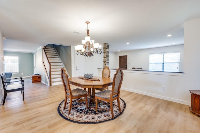 dining space featuring visible vents, baseboards, light wood-style floors, and stairs