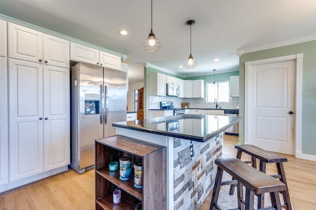 kitchen with white cabinets, backsplash, appliances with stainless steel finishes, and ornamental molding