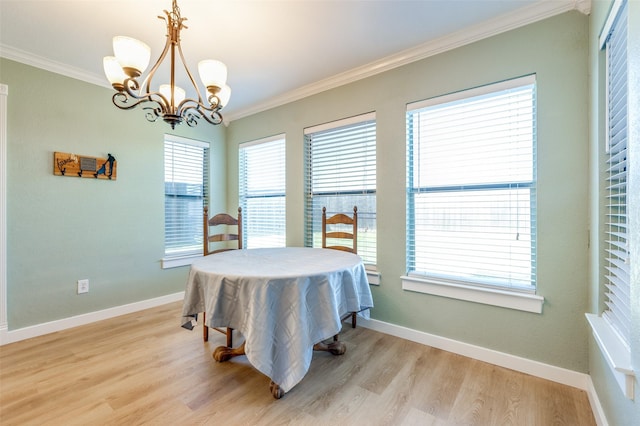 dining room featuring a chandelier, baseboards, light wood-style floors, and ornamental molding