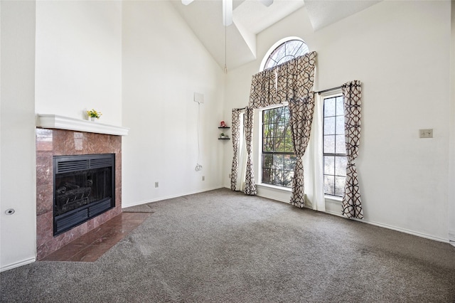 unfurnished living room featuring baseboards, carpet floors, high vaulted ceiling, and a fireplace