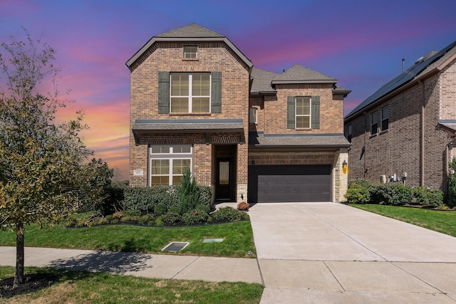 view of front of house with brick siding, an attached garage, and driveway