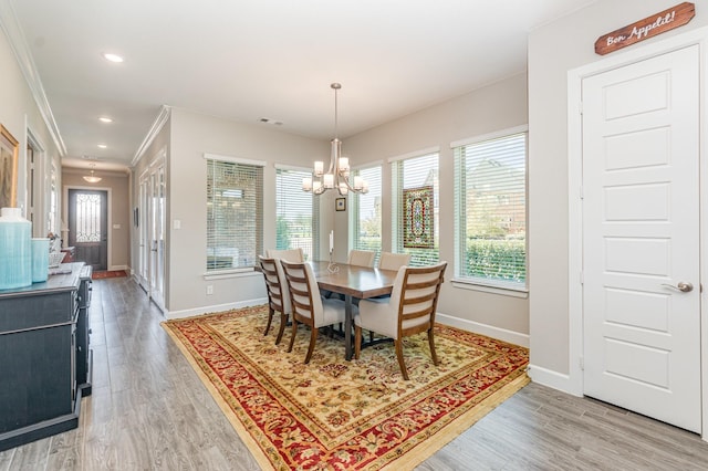 dining space featuring visible vents, light wood-style flooring, baseboards, and ornamental molding