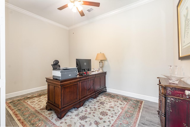 home office featuring a ceiling fan, light wood-type flooring, baseboards, and ornamental molding