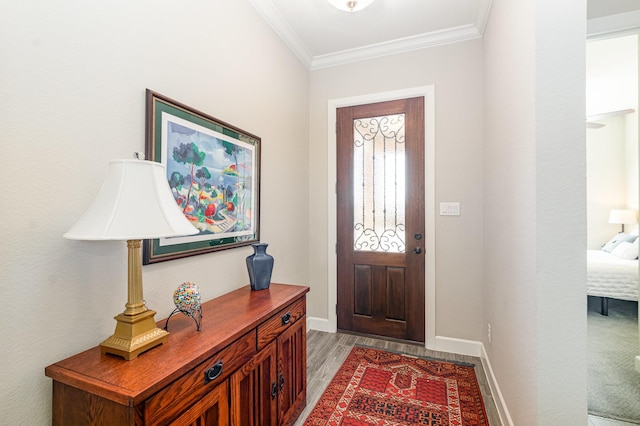 entrance foyer featuring light wood finished floors, baseboards, and ornamental molding