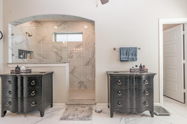 bathroom with baseboards, marble finish floor, and a marble finish shower