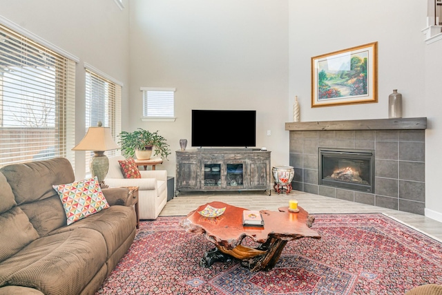 living room featuring a high ceiling, wood finished floors, and a fireplace