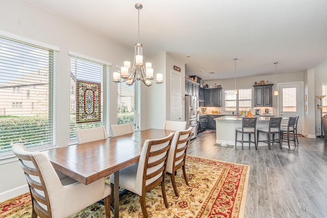 dining space with light wood-type flooring, plenty of natural light, and baseboards