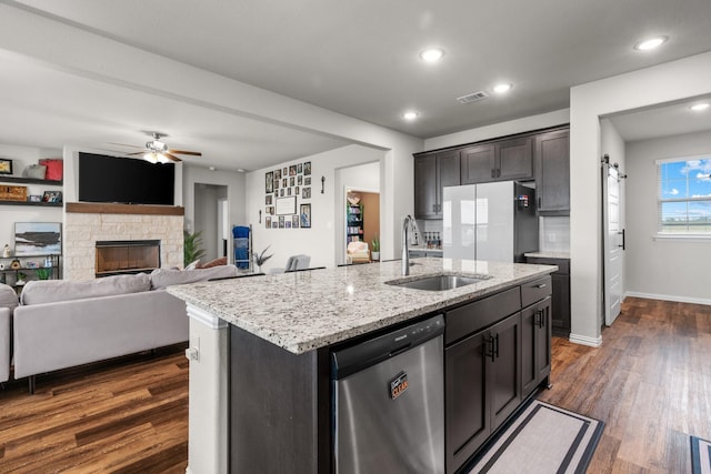kitchen featuring dark wood-style floors, visible vents, freestanding refrigerator, a sink, and dishwasher